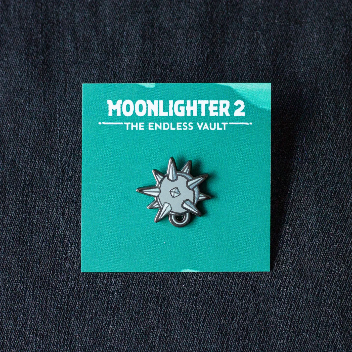 Pin „Moonlighter 2” — Trägerkarte mit Logo